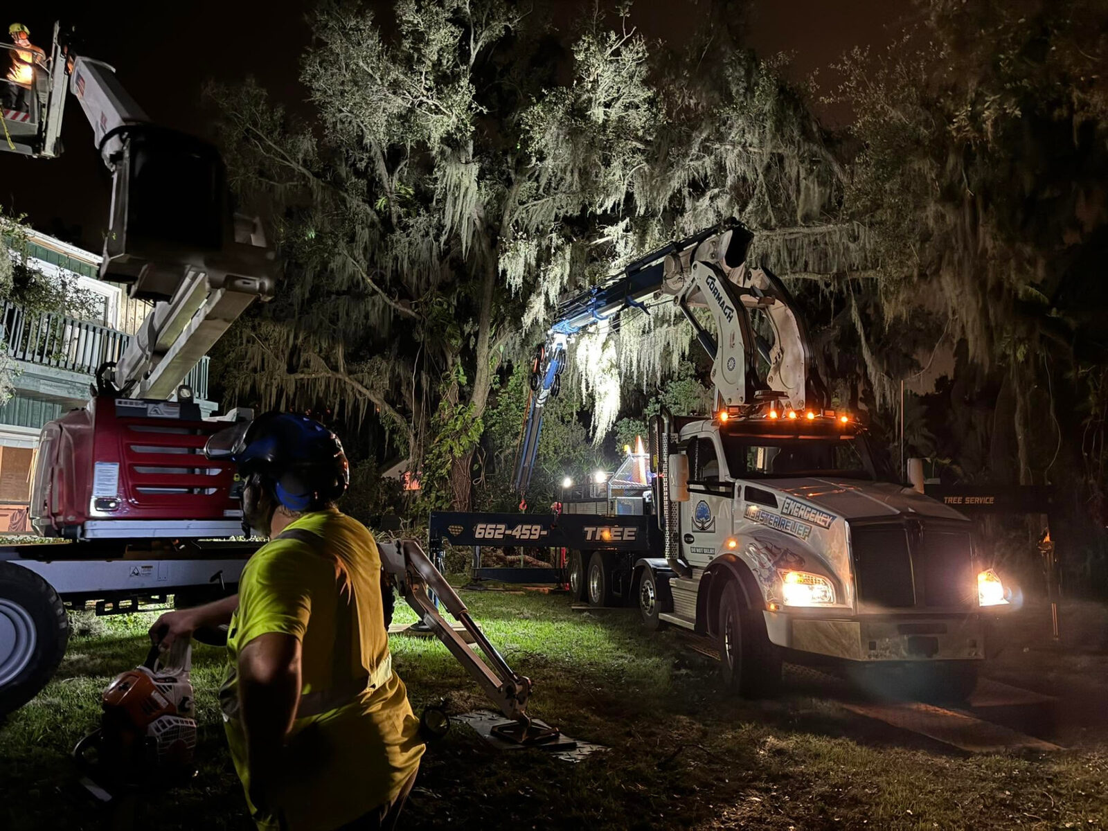 Night emergency tree removal with crane lights on